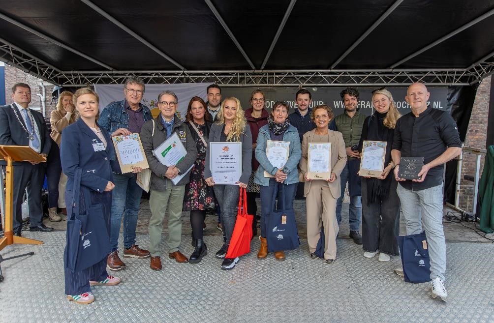 de Nieuwe Cittaslow Ambassadeurs staan op een podium met het certificaat in handen